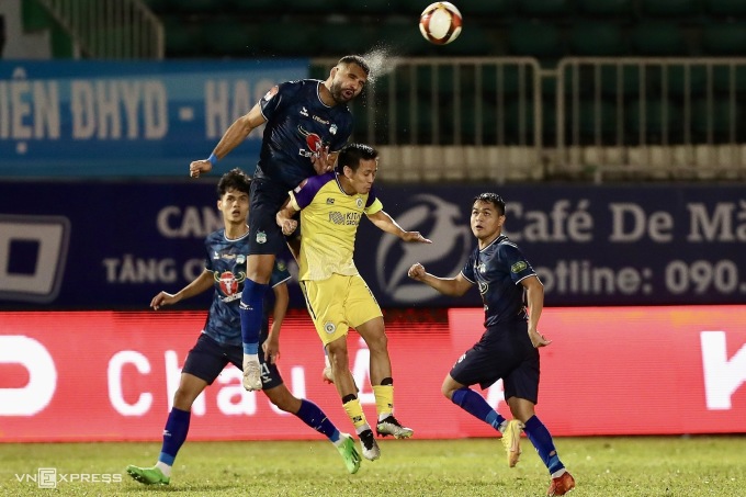 Tiền đạo Hà Nội FC Nguyễn Văn Quyết tranh chấp bóng bổng với trung vệ HAGL Jairo Rodrigues trên sân Pleiku ở vòng 8 V-League 2023-2024 ngày 27/12. Ảnh: Minh Trần