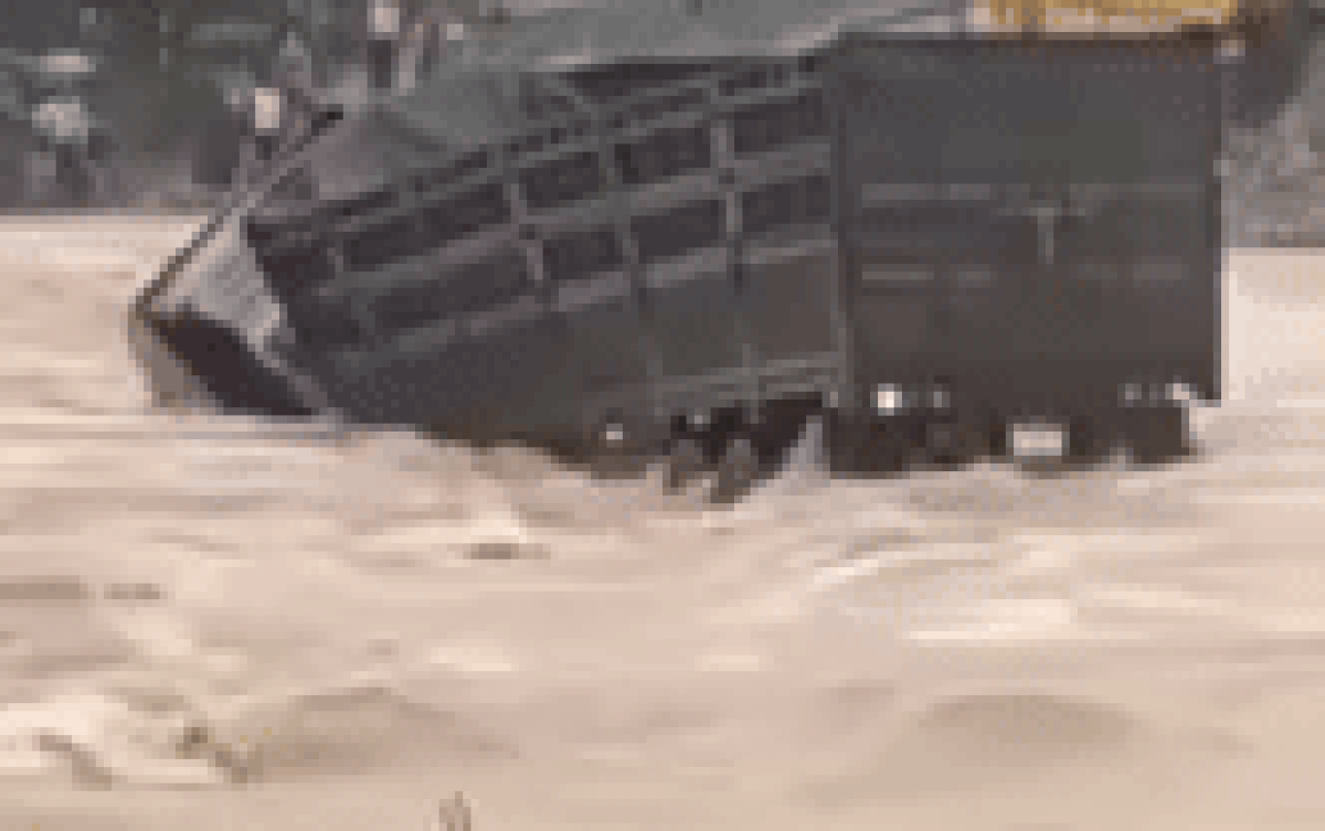 Khoảnh khắc nam tài xế nhảy khỏi thùng xe trước khi bị dòng nước lũ cuốn trôi mất tích. Ảnh cắt từ clip